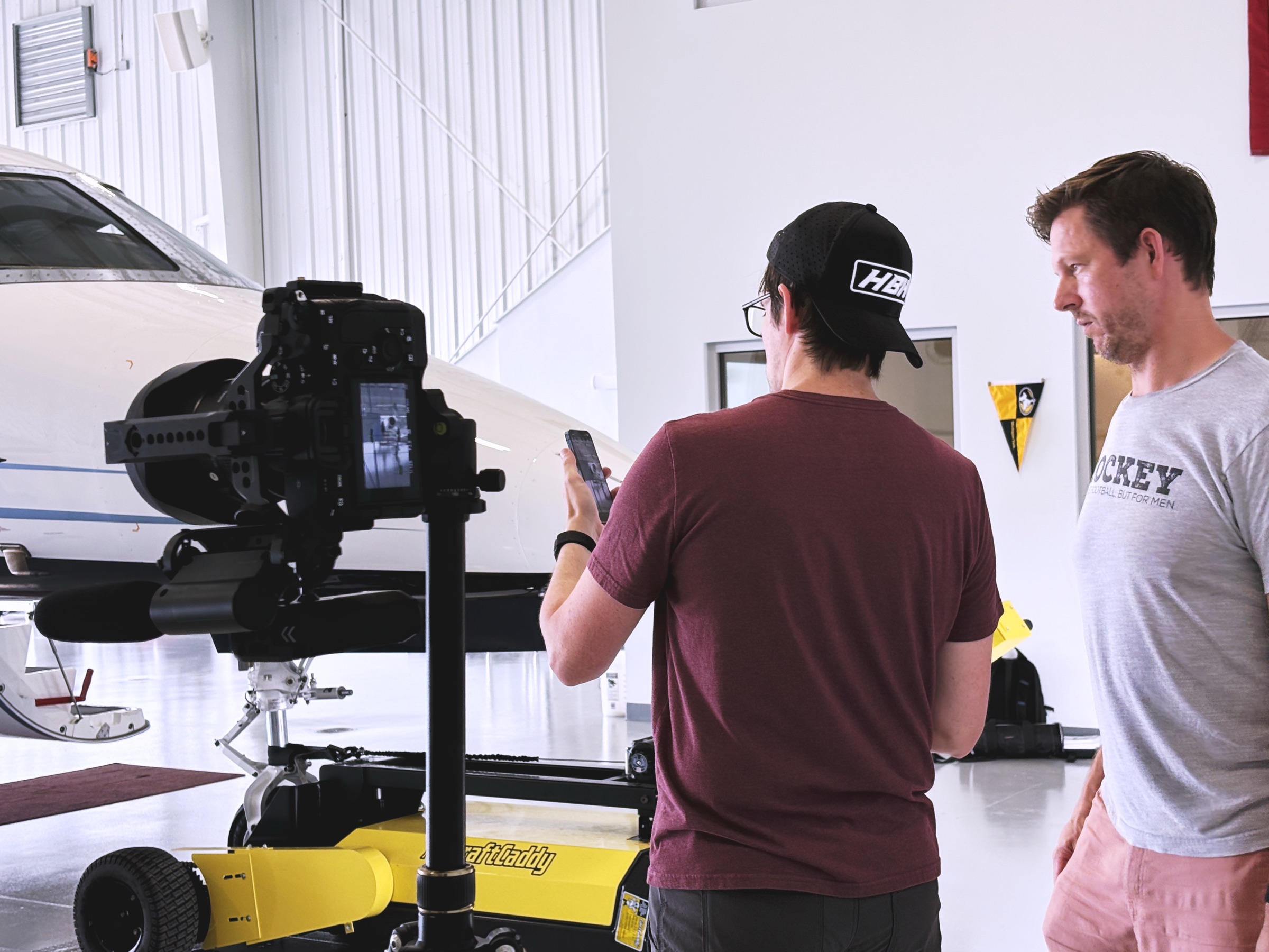 Boda Studios crew filming with a camera slider inside an aircraft hangar in Charleston